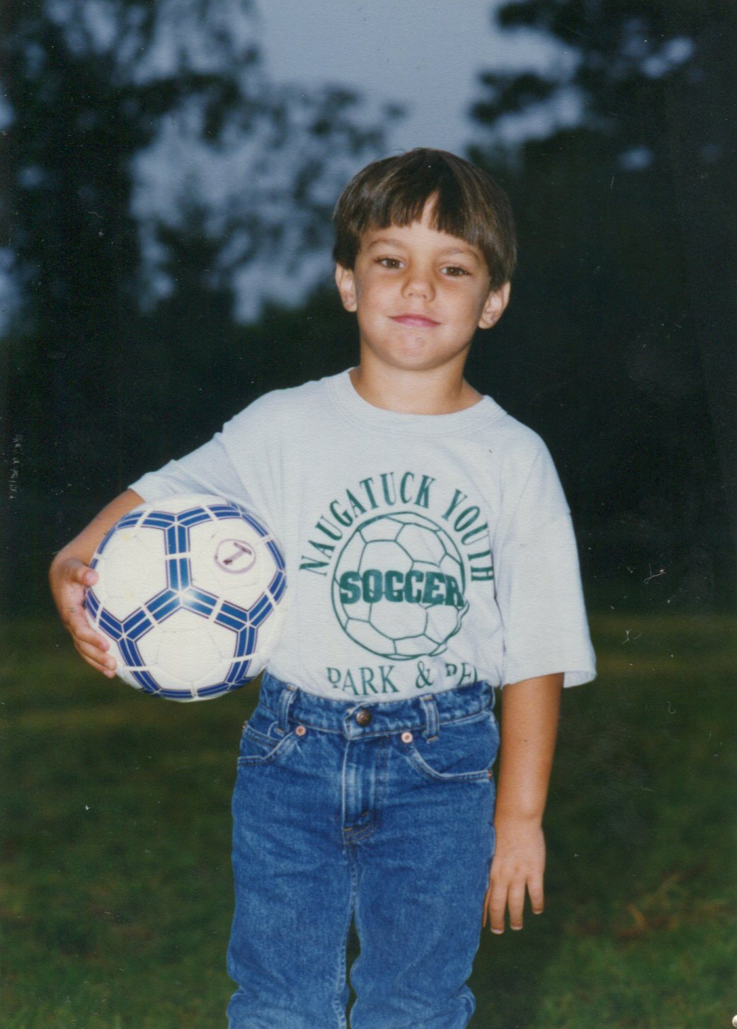 Jim as a kid, holding a soccer ball